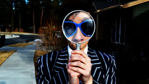 Woman with a magnifying glass. Photo by Marten Newhall on Unsplash. 